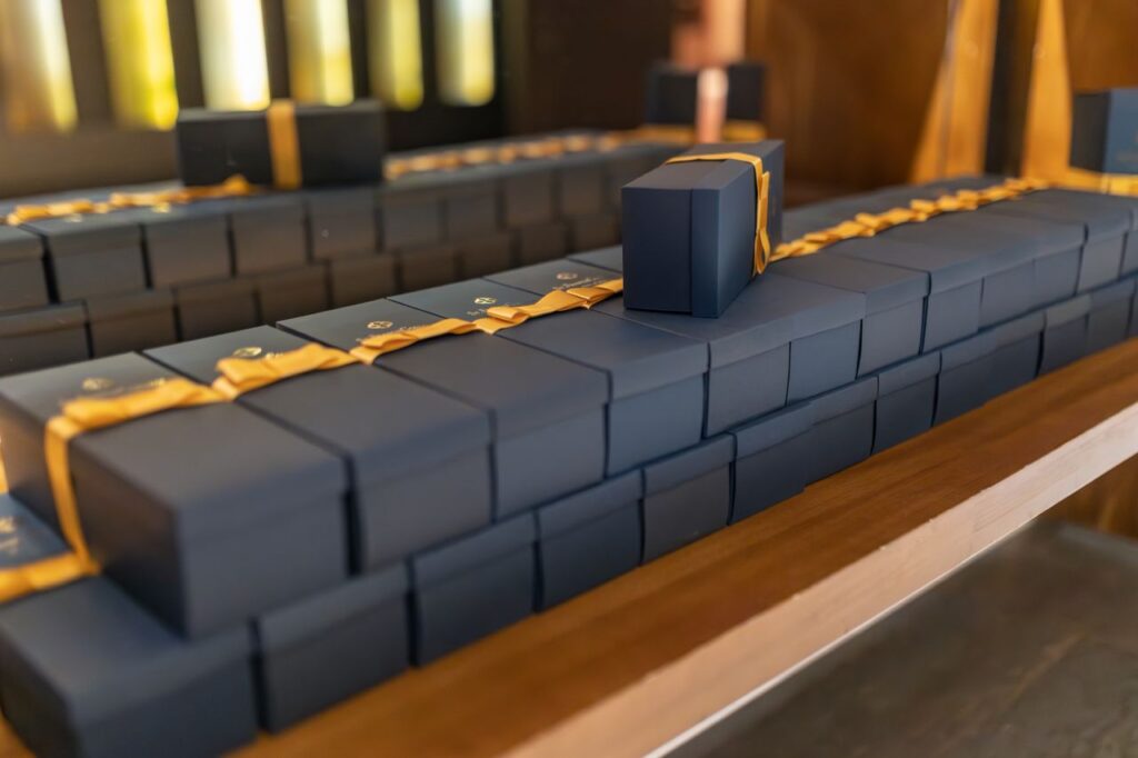 Elegant black gift boxes adorned with gold ribbons, perfect for luxury events or holiday celebrations.